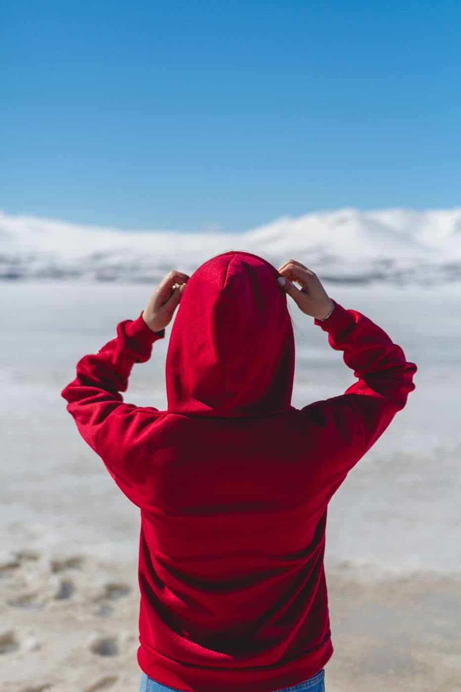 Back view of a red pullover hoodie with the hood up